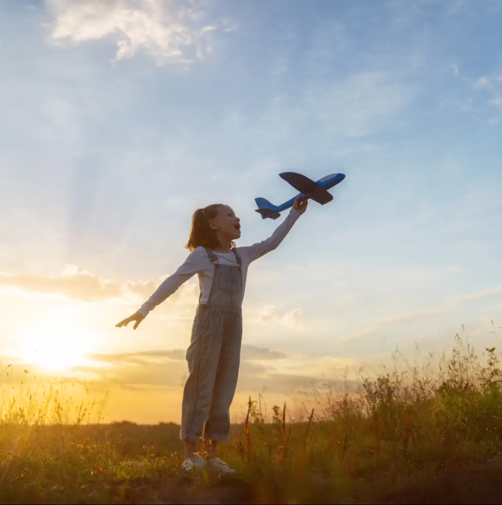 Bambina futuro pilota che gioca con un aeroplano giocattolo e sogna di volare